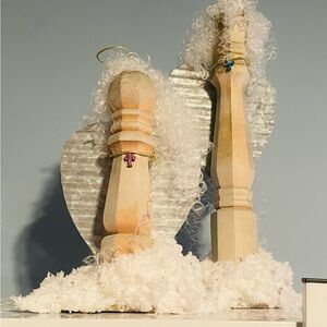 Handcrafted wooden angels with curly hair and wings of metal. Made from finial.